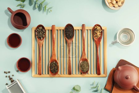 Photo for Beautiful set for traditional tea ceremony and tea collection in wooden spoons on light blue background flat lay - Royalty Free Image