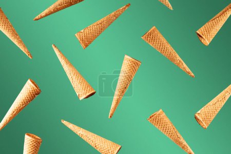 Téléchargez les photos : Modèle de cônes de crème glacée. Fond dégradé vert. Concept doux, estival et vide. Lévitation de crème glacée. Vue de dessus. Pose plate - en image libre de droit