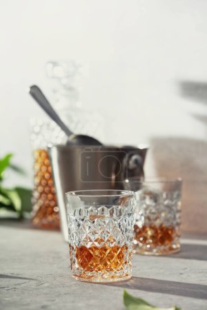 Photo for Whiskey with ice close up. Grey stone background - Royalty Free Image