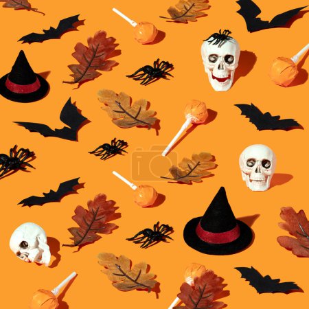 Photo for Happy Halloween concept. Overhead close up view photo of pattern of funny spiders, autumn leaves, hats, candies and bats isolated on orange background - Royalty Free Image