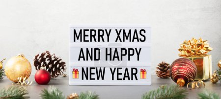 Téléchargez les photos : Lightbox avec texte Joyeux Noël et bonne année et décor de Noël sur la table sur fond blanc. Bannière vue de face - en image libre de droit