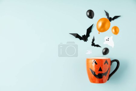 Photo for Happy halloween holiday concept. Halloween decorations, bats, ghosts, spiders, pumpkins, skull, cup of Chocolate with marshmallow on blue background. Halloween party poster mockup with copy space. - Royalty Free Image