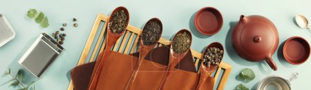Foto de Hermoso conjunto para la ceremonia tradicional del té y la colección de té en cucharas de madera sobre fondo azul claro - Imagen libre de derechos