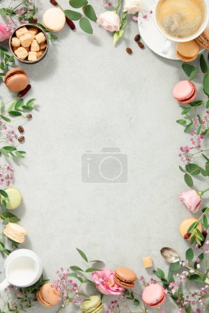 Foto de Marco hecho de flores de primavera, diferentes tipos de macarrones y café plano - Imagen libre de derechos