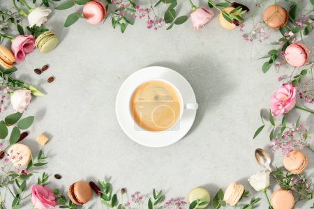 Photo for White cup of coffee and Frame made of Spring flowers and Different types of macaroons flat lay - Royalty Free Image