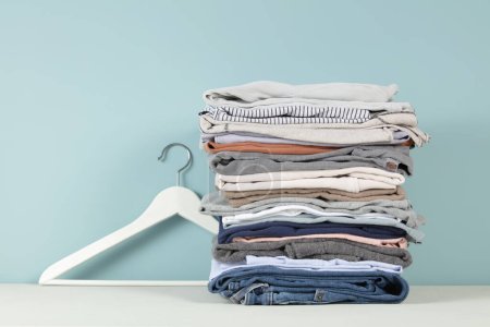 stack of folded clothes, blue background, copy space