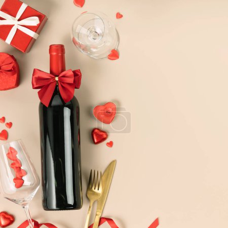 Foto de Beautiful romantic table setting with wine, roses and gifts on beige background. Romantic dinner. Valentines Day. Top view, flat lay, copy space - Imagen libre de derechos