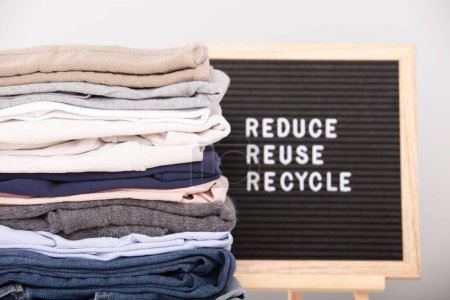 Boîte aux lettres noire et pile de vêtements pliés, réduire, réutiliser, recycler devis. Zéro gaspillage mode de vie durable. Concept sans plastique. 