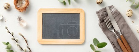Photo for Easter table decorations. Stylish Easter brunch table setting with chalkboard, vintage cutlery, easter eggs and spring branches on light grey background top view flat lay copy space - Royalty Free Image