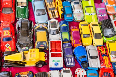 Téléchargez les photos : Collection de voitures miniatures colorées vintage le long d'un marché aux puces de rue. - en image libre de droit