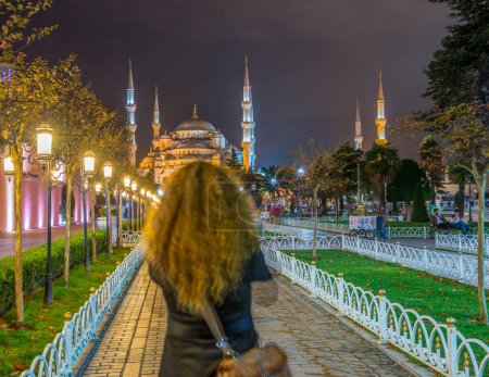 Téléchargez les photos : ISTANBUL - 17 SEPTEMBRE 2014 : Les touristes profitent de la vue nocturne sur la Mosquée Bleue. Istanbul accueille chaque année plus de 11 millions de visiteurs
. - en image libre de droit