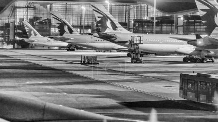 Photo for Doha, Qatar - August 17, 2018: Airplanes at night on the runway of Hamad International Airport. - Royalty Free Image