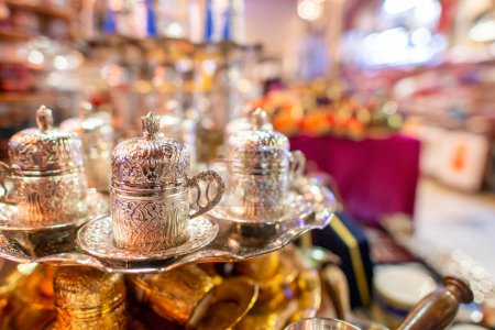 Téléchargez les photos : Tasses à thé en argent de style arabe dans un marché de rue la nuit. - en image libre de droit