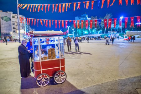 Photo for Istanbul, Turkey - October 2014: Street food seller at night along the crowded Taksim Square. - Royalty Free Image