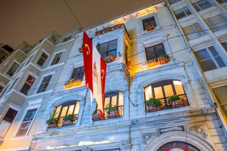 Téléchargez les photos : Façade du bâtiment à Istanbul avec drapeau turc la nuit. - en image libre de droit