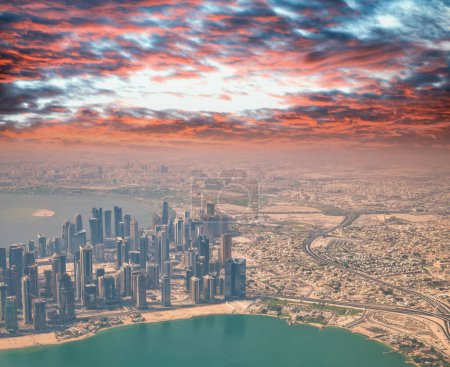 Téléchargez les photos : Vue aérienne de Doha depuis l'avion. gratte-ciel modernes au coucher du soleil, Qatar. - en image libre de droit
