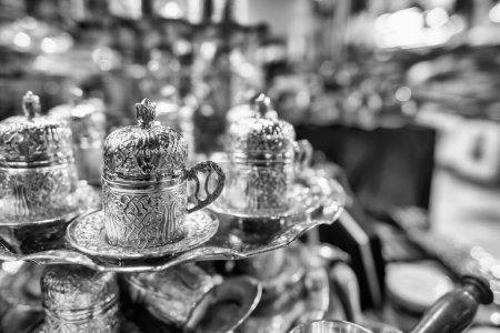 Foto de Tazas de té de plata en estilo árabe en un mercado callejero por la noche. - Imagen libre de derechos