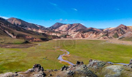 Téléchargez les photos : Paysage islandais célèbre dans les hautes terres, région Landmannalaugar Islande. Champs de lave verts et montagnes en arrière-plan, vue aérienne - en image libre de droit