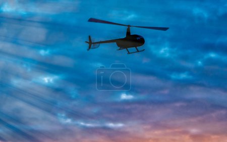 Photo for Helicopter silhouette with sunset sky on the background - Royalty Free Image