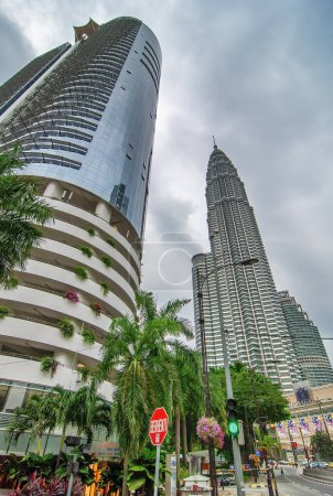 Foto de Kuala Lumpur, Malasia - 9 de agosto de 2009: Torres Gemelas Petronas y rascacielos en un día nublado. - Imagen libre de derechos