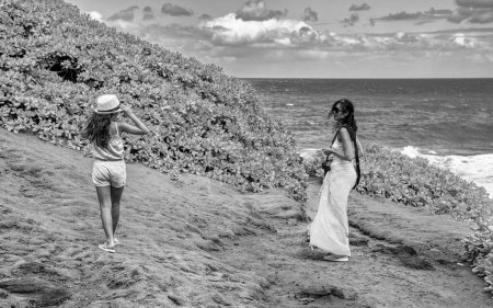 Téléchargez les photos : Famille en voyage à travers l'île. Femme et fille sur un sentier de montagne - en image libre de droit