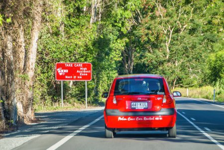 Téléchargez les photos : Port Douglas, Australie - 22 août 2009 : Voiture rouge le long de la route menant au parc national Daintree. - en image libre de droit