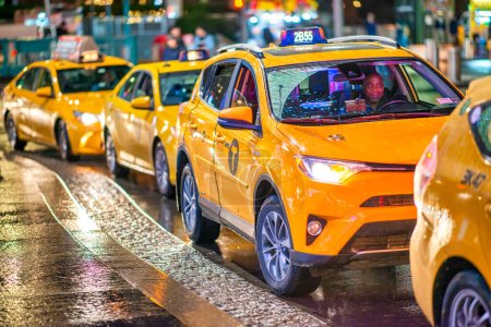Foto de Nueva York, NY - 2 de diciembre de 2018: Cola de taxis esperando a los clientes por la noche en Manhattan. - Imagen libre de derechos