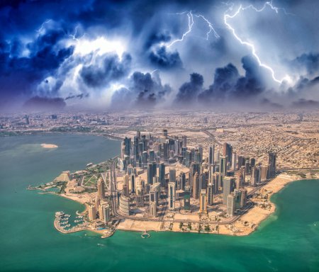 Foto de Vista aérea del horizonte de Doha desde el avión durante una tormenta. Corniche y edificios modernos, Qatar. - Imagen libre de derechos