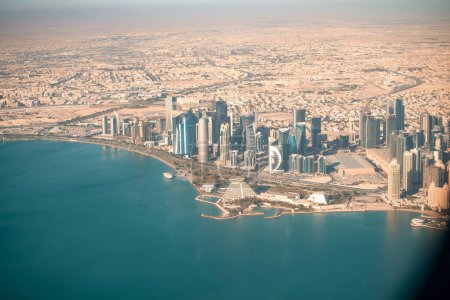 Photo for Doha, Qatar - December 12, 2016: Aerial view of city skyline from a flying airplane over the Qatar capital. - Royalty Free Image