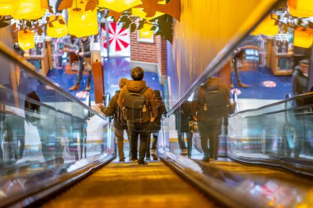 Photo for People going down the escalator in a toy store. - Royalty Free Image