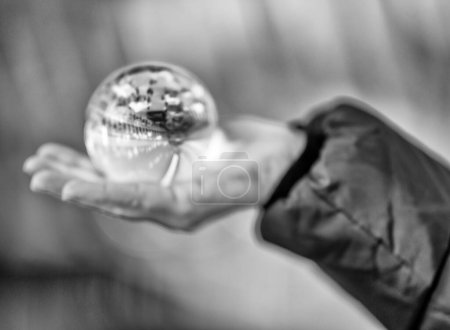 Photo for Crystal ball in the hand of a woman showing modern building interior - Royalty Free Image