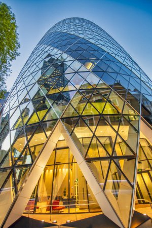 Photo for LONDON, UK - JUNE 2015: The modern glass buildings of the Swiss Re Gherkin. This tower is 180 meters tall and stands in the City of London Financial District. - Royalty Free Image