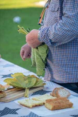 Téléchargez les photos : Homme âgé préparant la table en plein air pour couper les figues - en image libre de droit