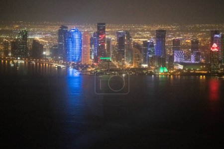 Foto de Vista aérea nocturna del horizonte moderno de Doha desde el mar. - Imagen libre de derechos