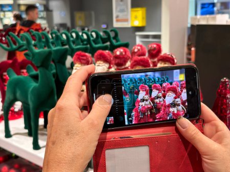 Téléchargez les photos : Femme prenant des photos de belles décorations de Noël avec son smartphone. - en image libre de droit