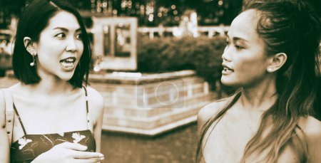 Foto de Dos hermosas mujeres asiáticas jóvenes hablando y relajándose caminando por las calles de la ciudad. - Imagen libre de derechos