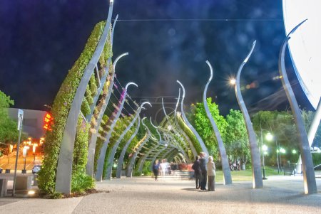 Photo for Tourists along the South Bank Grand Arbour at night in Brisbane, Australia. It is a 1km long arbour, curled spires draped in ever blooming bougainvillea. - Royalty Free Image