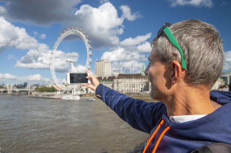 Foto de Hombre fotografiando Londres con un smartphone en un día soleado. - Imagen libre de derechos