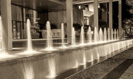 Photo for Colorful small fountains in front of a luxurious hotel at night. - Royalty Free Image