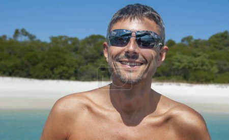Foto de Retrato de un hombre caucásico feliz relajándose en un hermoso paisaje de playa. - Imagen libre de derechos