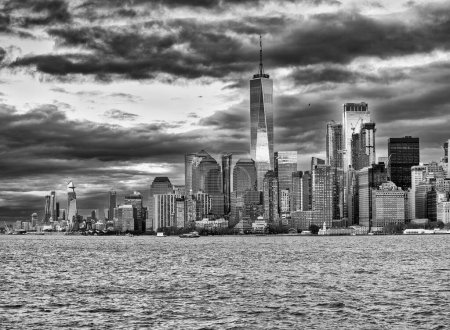 Téléchargez les photos : Coucher de soleil sur l'horizon du Lower Manhattan depuis un bateau dans le port de New York - en image libre de droit