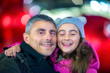 Foto de Chica joven y feliz abrazando a su padre en las calles de la ciudad de Nueva York para las vacaciones de Navidad. - Imagen libre de derechos