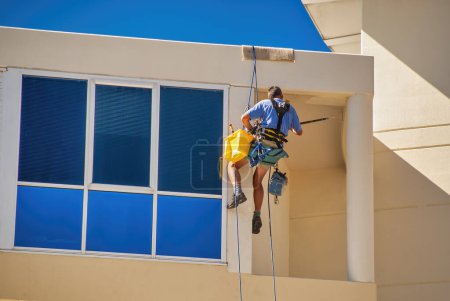 Photo for Public worker cleaning windows on the top of a tall building. - Royalty Free Image