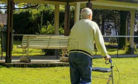 Foto de Hombre mayor jubilado con paseantes paseando por el jardín.. - Imagen libre de derechos