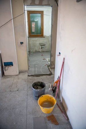 Téléchargez les photos : Poser les carreaux sur le sol de la salle de bain. Passage à un nouveau concept de maison. - en image libre de droit