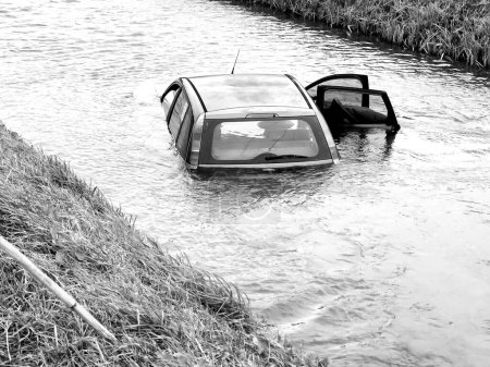 Téléchargez les photos : Une voiture grise tombe et se noie dans la rivière. - en image libre de droit
