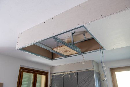 Téléchargez les photos : Travaux de finition dans une nouvelle maison. Plafonds suspendus Préparation de plafond de cloison sèche pour la lumière menée - en image libre de droit
