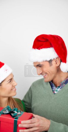Téléchargez les photos : Happy holiday couple exchanging Christmas gifts at home. - en image libre de droit