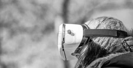 Téléchargez les photos : Femme heureuse portant une visière de réalité virtuelle explorant le parc de la ville. - en image libre de droit