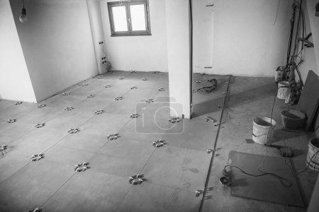 Photo for Laying the tiles on the floor. Moving to a new house concept. Basement room. - Royalty Free Image
